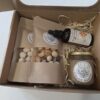 Otvoreni mali poklon-paket s vrećicama lješnjaka, maslacem i uljem